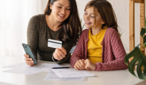 mother teaching daughter about debit card use
