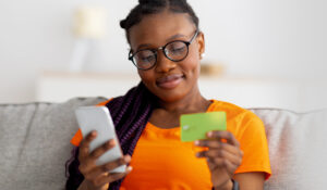 woman making a payment with cell phone and credit card