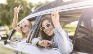 two happy women on road trip on sunny day