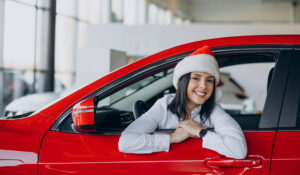woman wearing Santa hat inside a new car
