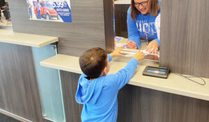 small child making an account deposit at TCCU