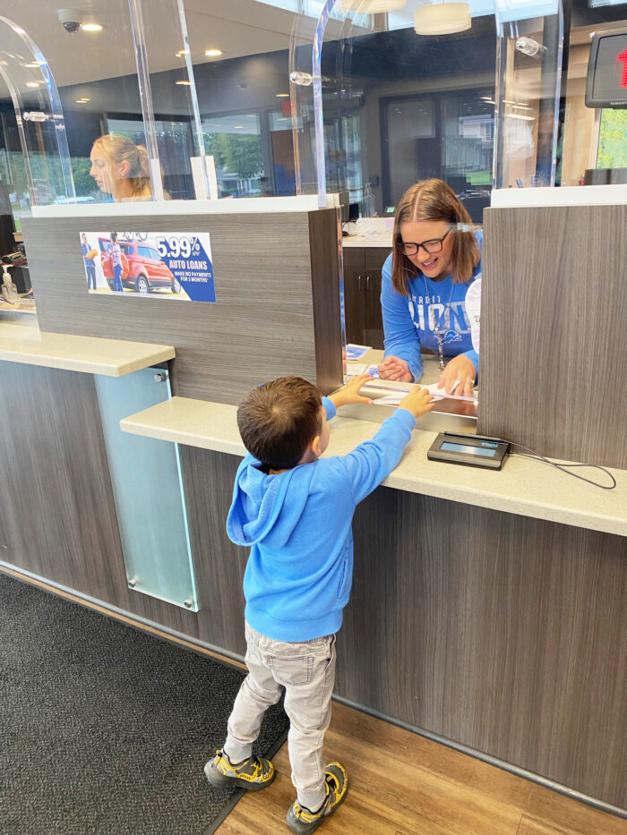 small child making an account deposit at TCCU