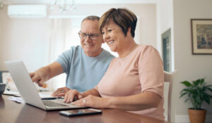 happy mature couple using laptop