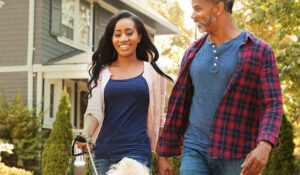 couple walking their dog in residential neighborhood