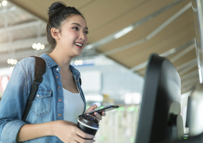 happy young woman paying for coffee with debit card pay-app
